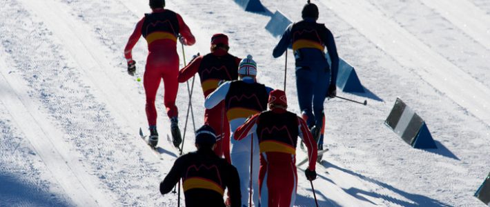 A group of men head to the finish line in a cross country ski race.